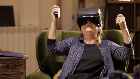 Mature-woman-playing-with-virtual-reality-headset-at-smart-home