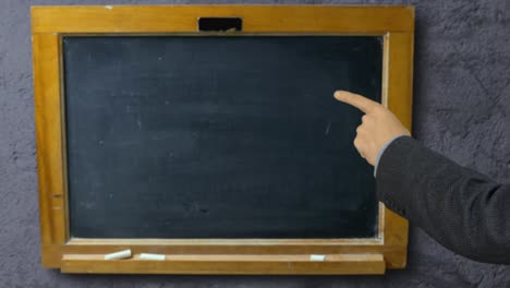 Man-hand-pointing-with-index-finger-on-blackboard-school