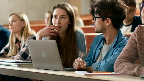 In-der-Klasse-weibliche-und-männliche-Studenten-teilen-und-Laptop,-auf-einem-Vortrag-im-Chat-nutzen.-Junge-Menschen-studieren-und-lernen.-Uni-Leben.