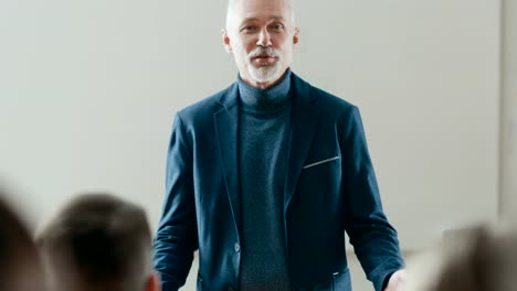 Camera-Facing-Class:--Prominent-Professor-Writing-on-the-Blackboard-and-Giving-Lecture-to-a-Class-of-Multi-Ethnic-Students.-Modern-University-with-Bright-Young-People.