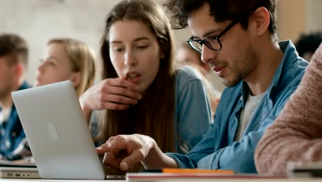 In-der-Klasse-weibliche-und-männliche-Studenten-teilen-und-Laptop,-auf-einem-Vortrag-im-Chat-nutzen.-Junge-Menschen-studieren-und-lernen.-Uni-Leben.