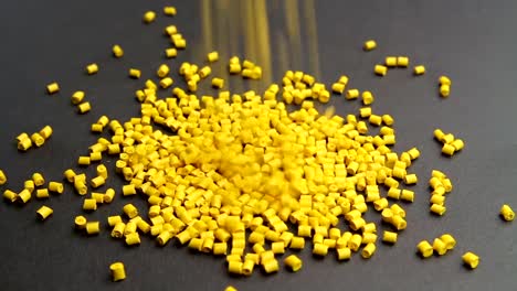 Plastic-pellets-crumbles-to-the-table-.-Plastic-raw-materials-in-granules-for-industry.-Polymer-resin.