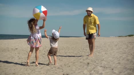 Father-enjoying-playing-ball-with-young-little-kid-on-beach.-Family-Summer-Beach-Vacation.-Slow-Motion.-Children-play-with-dad-on-the-beach.