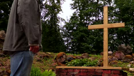 Man-with-rosary-staying-near-cross-at-outdoor