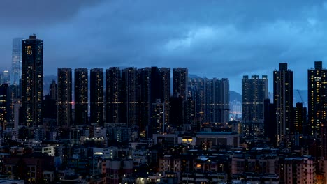 Día-de-lapso-de-tiempo-a-la-noche.-Vista-aérea-de-apartamentos-Hong-Kong-en-el-fondo-del-paisaje-urbano,-Sham-Shui-Po-distrito.-Barrio-residencial-en-la-ciudad-inteligente-en-Asia.