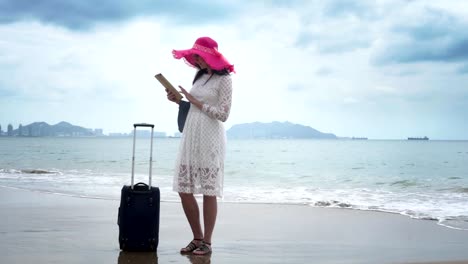 Turista-de-chica-con-un-bolso-grande-es-mirando-en-el-ipad