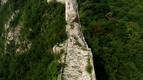 Luftaufnahme-des-jungen-Fitness-Frau-Trailläufer-läuft-oben-auf-der-Mauer