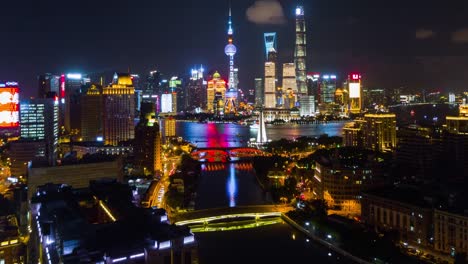 ilumina-la-noche-China-shanghai-panorama-aéreo-del-río-de-la-wusong-paisaje-urbano-pudong-4k-lapso-de-tiempo