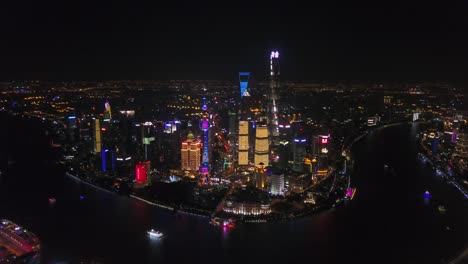 China-Shangai-paisaje-noche-iluminada-pudong-céntrico-lado-Bahía-panorama-aéreo-4k