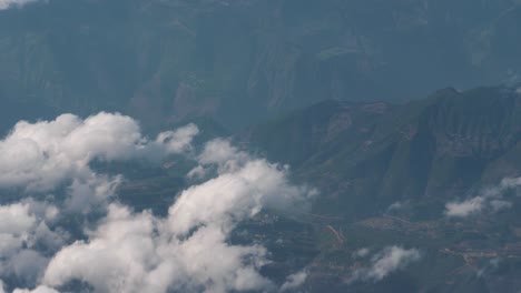 Beautiful-view-through-airplane-window,-airplane-flying-above-city-in-mountains