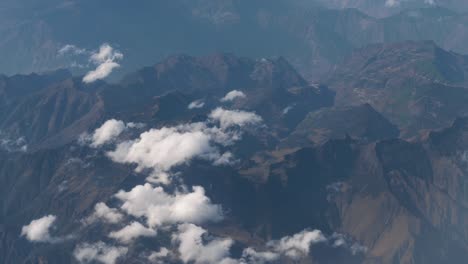 Beautiful-view-through-airplane-window,-airplane-flying-above-city-in-mountains