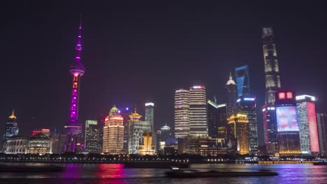 Lapso-de-tiempo-de-noche-panorámica-del-Skyline-de-Shanghai-iluminado.-Distrito-financiero-de-Lujiazui-y-río-Huangpu.-Vista-desde-el-terraplén-del-Bund.-China.