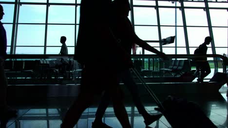 silhouettes-of-travelers-in-a-busy-airport-terminal