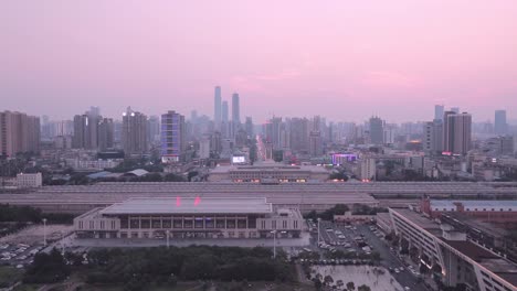 A-railway-station-with-a-clock-tower-and-a-city-tower-at-sunset