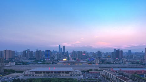 A-railway-station-with-a-clock-tower-and-a-city-tower-at-sunset