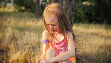 Little-girl-crying-sitting-in-a-tree-on-the-festival-of-colors-Holi