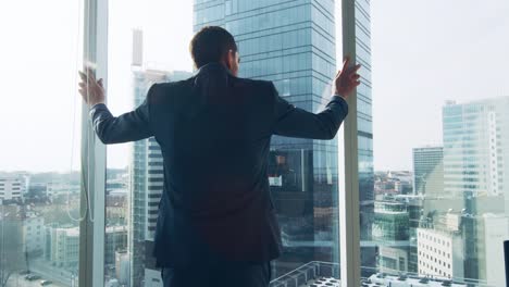 Folgenden-Schuss-der-zuversichtlich-Geschäftsmann-in-einem-Anzug-zu-Fuß-durch-sein-Büro-und-Suche-aus-dem-Fenster-nachdenklich.-Stilvolle-moderne-Business-Office-mit-PC-und-Blick-auf-die-große-Stadt.