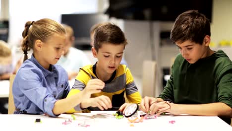 glückliche-Kinder-in-der-Robotik-Schule-machen-hohe-fünf