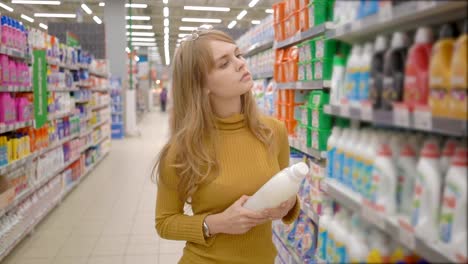 Junge-Frauen-die-Wahl-Haushaltschemikalien-im-Supermarkt.