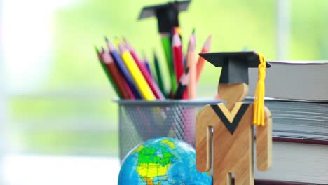 Education-knowledge-learning-study-abroad-international-Ideas.-People-Sign-wood-with-Graduation-celebrating-cap-on-open-textbook,-America-global-map-show-alternative-studying-Back-to-School-Concept