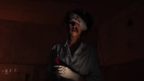 Monströse-Arzt-Blut-befleckt-und-mit-Pflaster-auf-einem-Auge,-hält-Spritze-mit-Blut