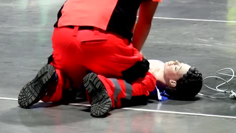 Health-care-worker-performing-CPR-on-mannequin-rear-view