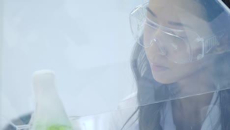 Female-medical-research-scientists-put-dry-ice-into-a-glass-beaker