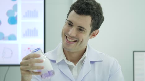 Portrait-of-Crazy-and-mad-scientist-looking-and-holding-laboratory-glass-bottle-with-purple-liquid