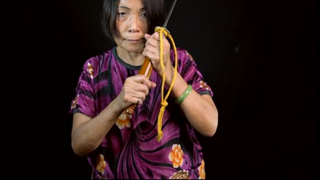 old-asian-woman-swings-vintage-sword