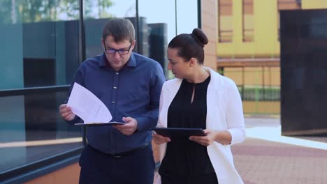 Business-man-and-business-girl-go-and-discuss-business-project