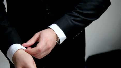 Businessman-buttoning-a-button-on-his-black-jacket