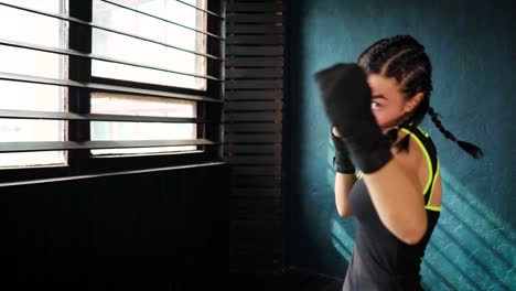 mujer-joven-hermosa-mueve-boxeo-entrenamiento-en-gimnasio-de-perforación