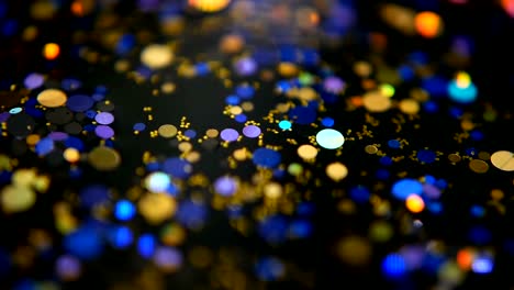 Defocused-shimmering-multicolored-glitter-confetti,-black-background.-Party,-magic,-imagination.-Rainbow-colors,-sparkle-circles.-Holiday-abstract-festive-texture-of-shiny-blurred-bokeh-light-spots.