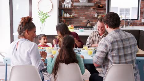 Multi-Generationen-Familie-beten-vor-dem-Essen-Tisch-zu-Hause