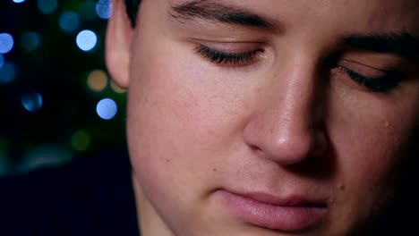 close-up-portrait-of-sad-depressed-young-man-starting-crying,-Christmas--half-face