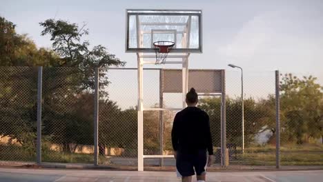 Jugador-de-baloncesto-femenino-caucásico-joven-ejercer-y-practicar-la-habilidad-de-manejo-de-pelota-en-cancha.-Vista-de-parte-trasera