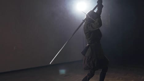 Medieval-warrior-training-with-two-handed-sword-indoors-in-slow-motion