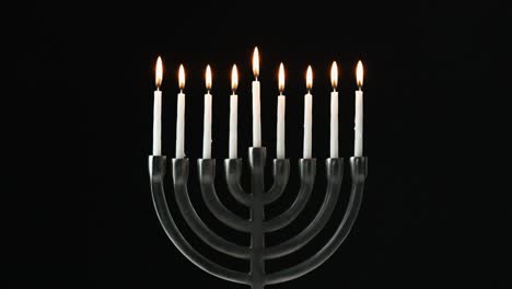 Una-fila-de-nueve-velas-blancas-en-una-menorah-están-soplados-hacia-fuera,-vista-frontal