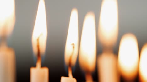 Tiro-de-foco-de-las-llamas-en-un-grupo-de-velas,-quema-de-la-festividad-judía-de-Hanukkah-en-rack