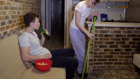 Esposa-hace-la-limpieza,-previniendo-al-marido-para-ver-fútbol