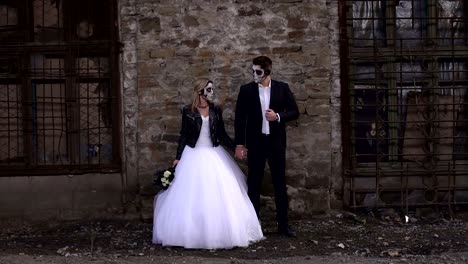 Couple-in-wedding-dresses-with-Halloween-makeup-near-an-old-brick-wall.