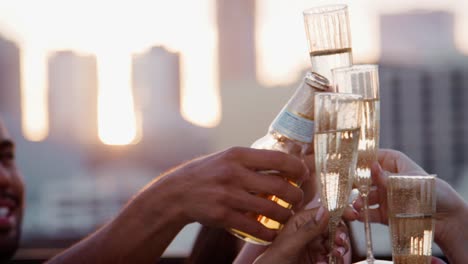 Cerca-de-amigos-con-bebidas,-hacer-un-brindis-en-la-terraza-de-la-azotea-con-el-horizonte-de-la-ciudad-en-segundo-plano