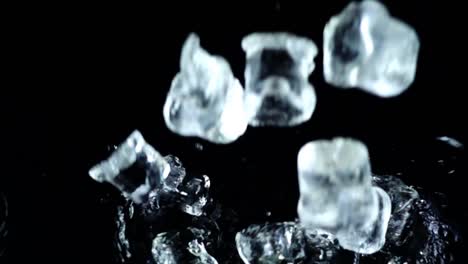 Falling-of-cubes-of-ice-on-a-black-background.-Slow-motion.