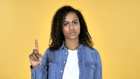 African-Girl-Waving-Finger-to-Refuse-Isolated-on-Yellow-Background