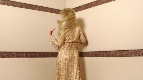 Porträt-einer-Frau-in-einem-langen-goldenen-Kleid,-mit-flatternden-langen-blonden-Haaren.