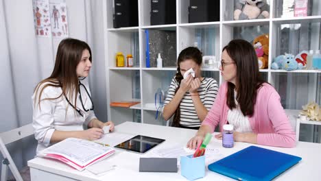 Madre-con-una-hija-frío-fui-al-doctor.-Madre-de-su-hija-adolescente-ante-al-médico-con-un-pañuelo-en-la-cabeza