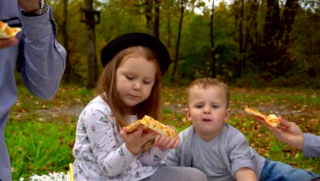 kleine-Mädchen-kaut-und-behandelt-ein-Stück-Pizza.