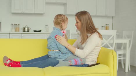 Caring-mother-consoling-her-upset-daughter-on-sofa