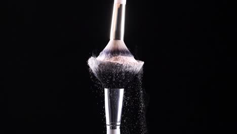 two-make-up-brushes-collide-creating-a-cascade-of-white-powder