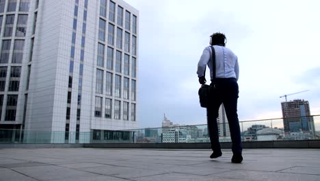 Feliz-hombre-de-negocios-negro-bailando-con-alegría-al-aire-libre